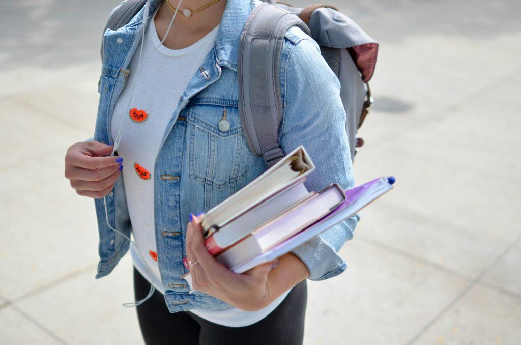 Student carrying books and backpack for college, modern education, university student with study materials, academic success, learning and knowledge concept, BPA Property relevance.