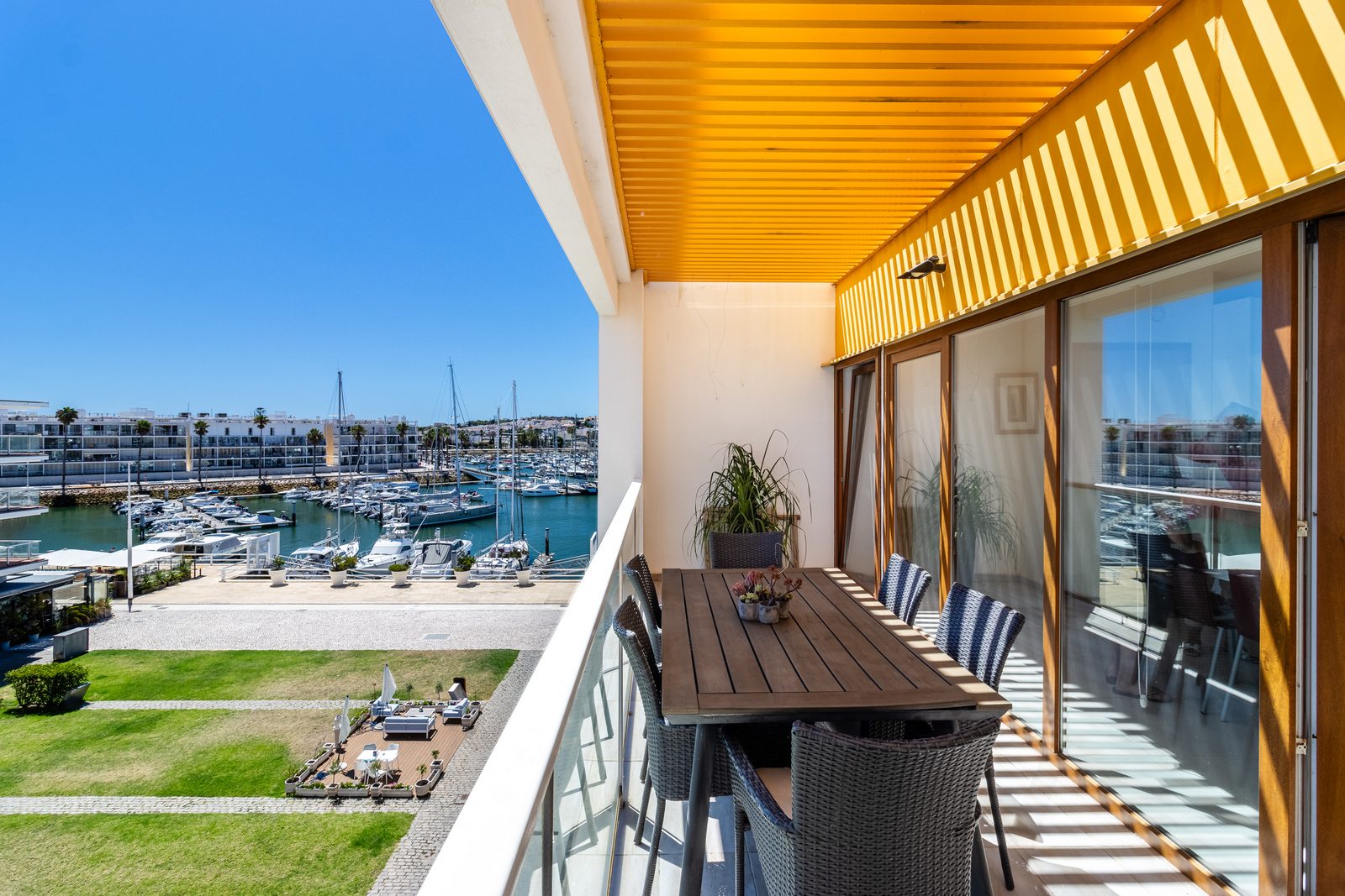 Covered balcony with dining table overlooking marina in the Algarve