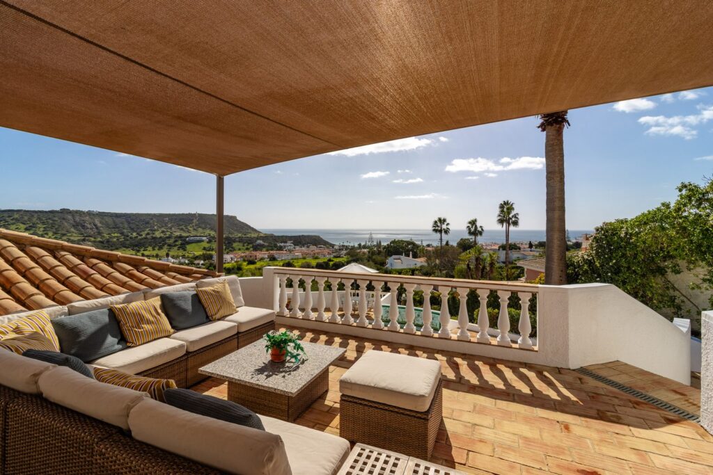 Covered terrace with seating and sea view in the Algarve